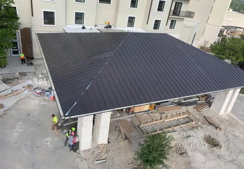 Metal roofing installation team working on a commercial building in Clay